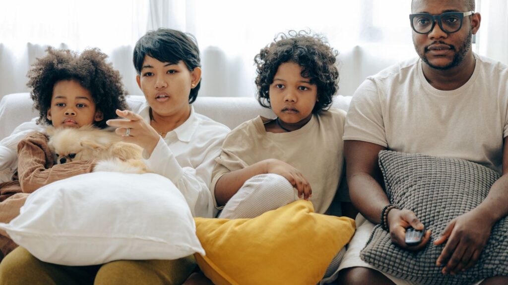 Familie samlet i sofaen foran TV-en hjemme