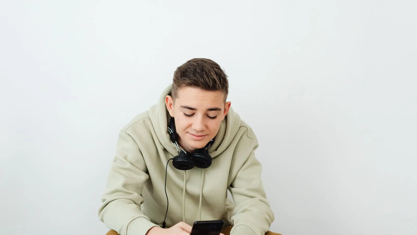 Ungdom med hodetelefoner ser på mobilen