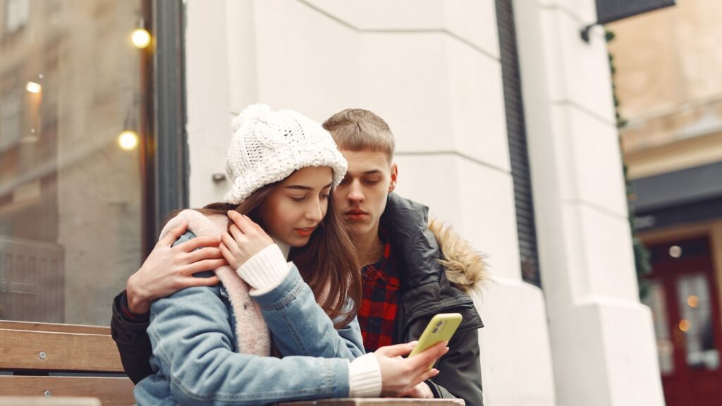 Familie ser på mobiltelefon sammen hjemme