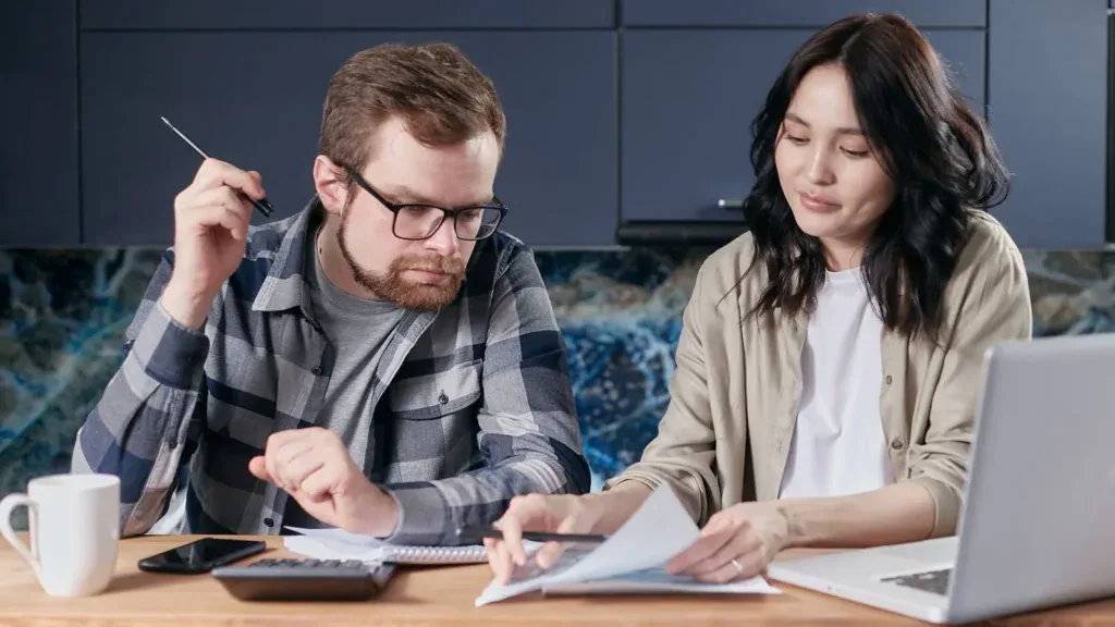 Familie regner på månedsprisen for mobil på laptop hjemme
