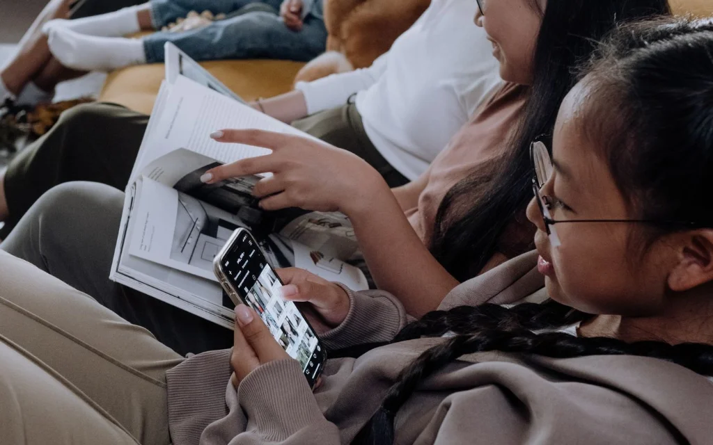 Familie i sofaen med mobiltelefoner og nettbrett