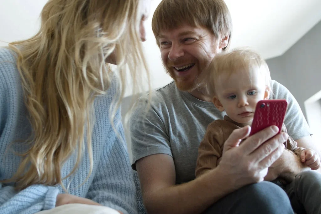 Familie ser på mobilen sammen hjemme