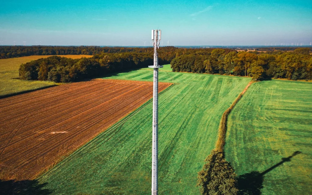 Mobilmast i grønt kulturlandskap sett fra luften