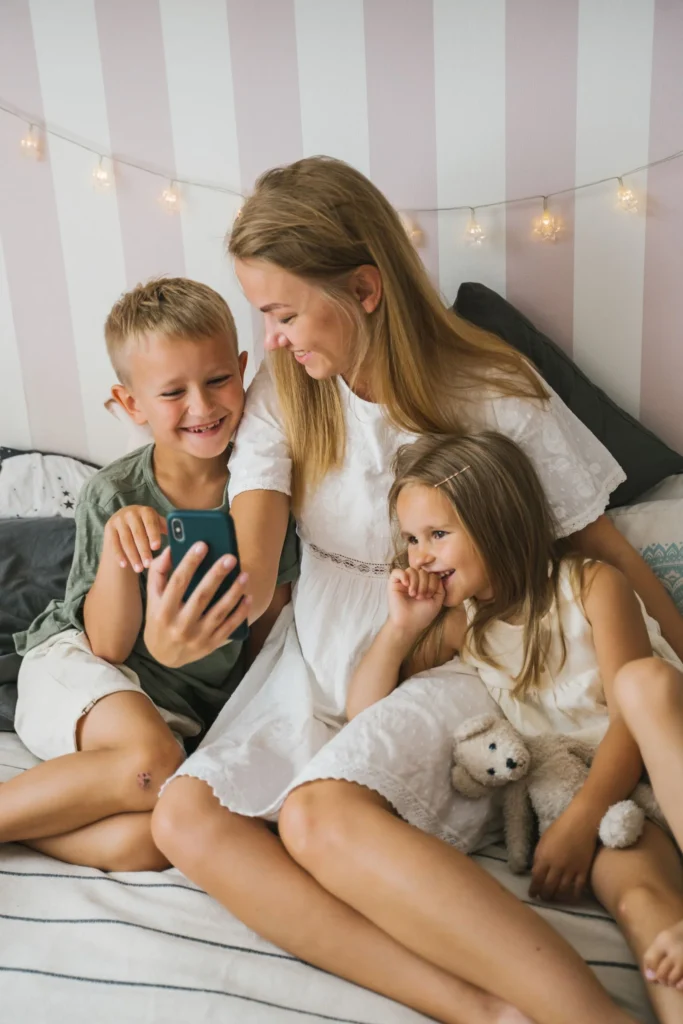 Mor og to barn ser på mobilen sammen