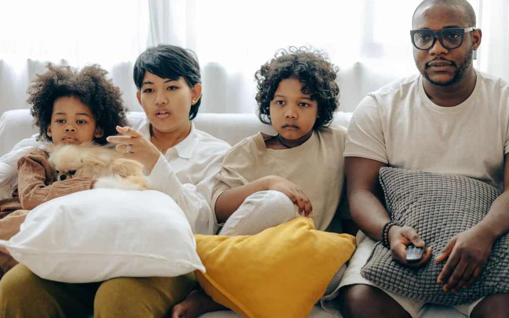 Familie ser film sammen i stua